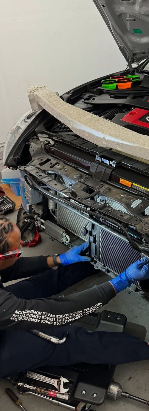 Technician working in an engine bay at the shop